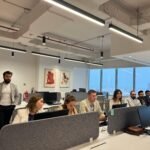 Professionals working in a modern office setting, collaborating and discussing business topics.